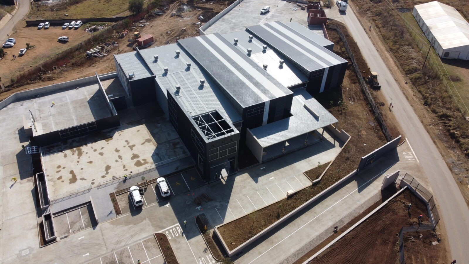 Aerial view of an industrial building with paved access roads and parking areas